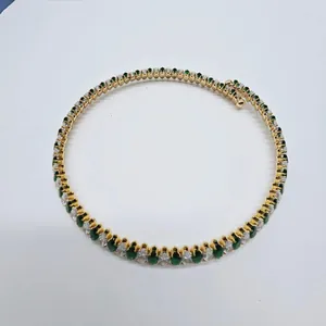 Close-up detail of a retro gold-plated choker with green and white marquise zircons.
