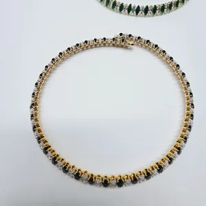 Close-up of elegant gold-plated necklace featuring black and clear oval zircons