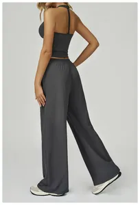 Vue arrière d'un ensemble de yoga gris avec haut licou et pantalon large fluide