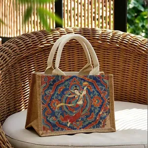 Sac cabas en jute écologique orné d'art mural de Dunhuang sur une chaise en osier chic