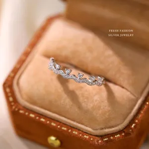 Exquisite macro detail of a wavy s925 sterling silver ring with clear stones in a velvet box