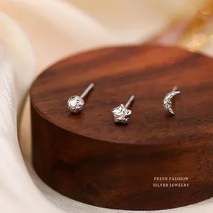 Detail view of s925 sterling silver stud earrings with moon, star, and ball designs