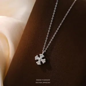 Detailed shot of s925 silver clover necklace with sparkling stones on brown display