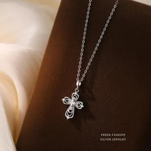 Detailed view of s925 silver filigree cross pendant necklace on brown velvet stand