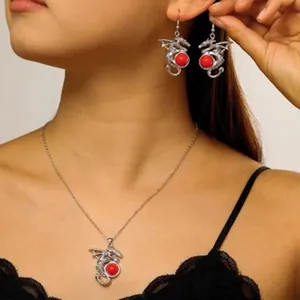 Close-up showing the detail of dragon-shaped necklace and earrings with red beads