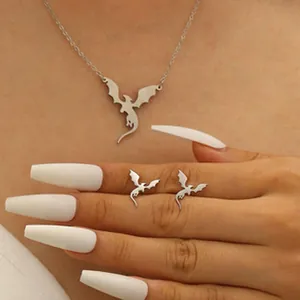 Detailed macro view of a silver flying dragon necklace and matching stud earrings set