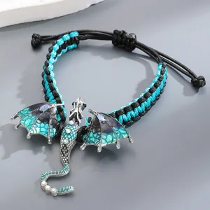 Detail of hand-woven bracelet featuring a teal enamel dragon with rhinestones