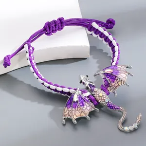 Macro view showing intricate purple enamel winged dragon pendant on a braided cord bracelet