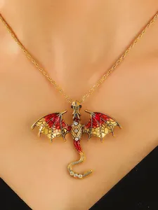 Close-up of a vintage golden dragon necklace with red enamel wings and sparkling crystal accents