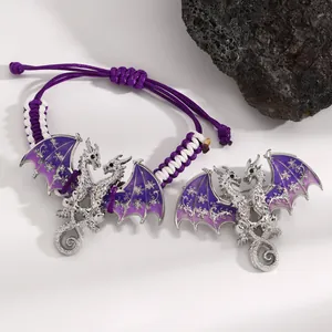 Detailed view of silver flying dragon jewelry with purple enamel wings and woven cord.