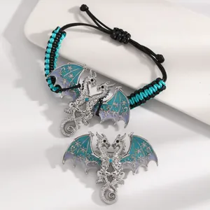 Detailed view of silver enamel dragon bracelet and brooch with blue wings