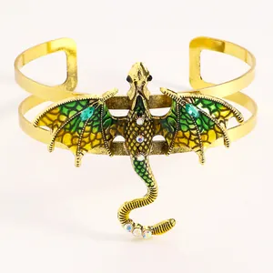 Detailed view of a vintage gold-tone cuff bracelet featuring a green enamel flying dragon.