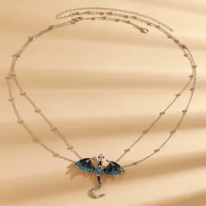 Detailed view of silver body chain featuring an intricate enamel flying dragon