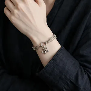 Close-up of vintage silver-tone multi-layer bracelet with fleur-de-lis pendant