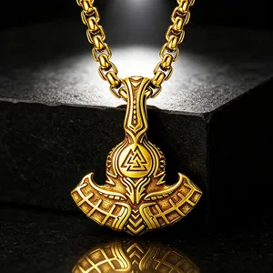 Detailed view of vintage gold Thor's axe pendant with Valknut symbol and ornate engravings.