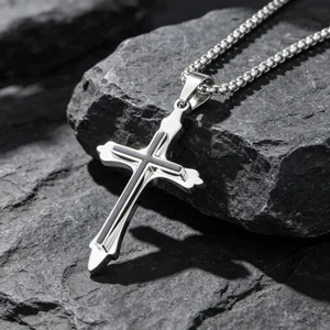 Premium titanium steel cross necklace for men displayed on a rugged stone background
