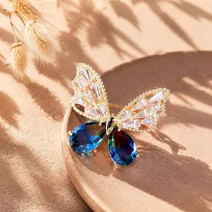 Elegante Spilla a Farfalla in Lega Placcata Oro per Donna con Cristallo Blu Sfumato e Strass Trasparenti Accessorio di Moda