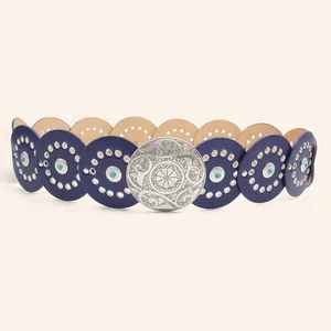 Detail van Western-riem met gegraveerde metalen gesp en blauwe lederen cirkels