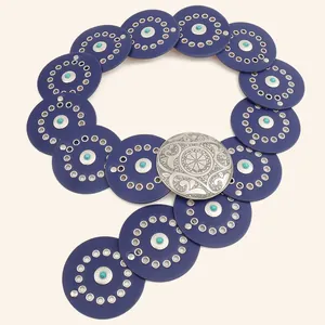 Detail van een brede vintage western riem met blauwe schijven en een zilveren gesp
