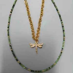 Vue détaillée du collier en perles vertes avec pendentif libellule dorée.