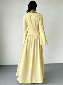 Achteraanzicht van een elegante gele maxi-jurk met lange mouwen in Franse stijl en geplooide taille.