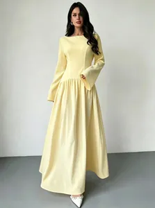 Gedetailleerd overzicht van een elegante gele maxi-jurk met boothals en wijde rok