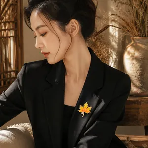 Detailed view of an elegant orange maple leaf brooch pinned on a black suit lapel