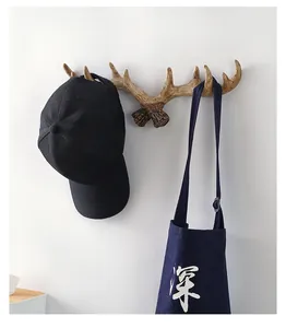 Vintage antler wall hook detail showing storage for hat and navy canvas tote bag