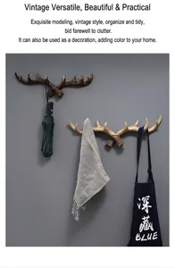 Detail of retro antler wall hooks holding umbrella and apron on gray wall
