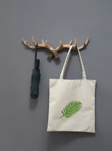 Detail van retro gewei wandhaak met een paraplu en een canvas tas