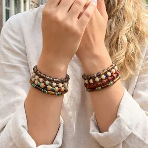 Detailed close-up showing stacked handmade Czech glass bead and stone bracelets on wrist