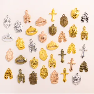 Detail view of assorted vintage alloy charms including helmets shields and swords for DIY jewelry.