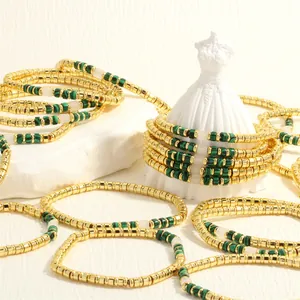 Gedetailleerde opname van gouden boho-armbanden met prachtige groene kralen in malachietstijl.