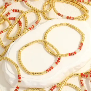 Detailweergave van Boheemse gouden kralenarmband met rode halfedelstenen