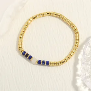 Gedetailleerde weergave van een bohemian kralenarmband met gouden buisjes en edelstenen