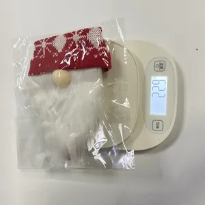 Detailed view of the 22.9g knitted Christmas gnome wine bottle cover in clear packaging