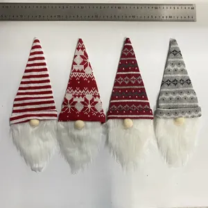 Knitted Christmas gnome wine bottle covers shown with a metal ruler for size reference