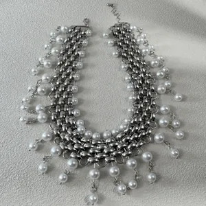 Close-up of a punk style chunky silver chain necklace adorned with white pearls