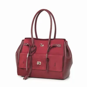 Primer plano de un bolso tote bordeaux de cuero esmerilado con elegantes herrajes.