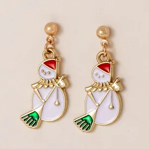 Gros plan détaillé de jolies boucles d'oreilles bonhomme de neige avec chapeaux rouges