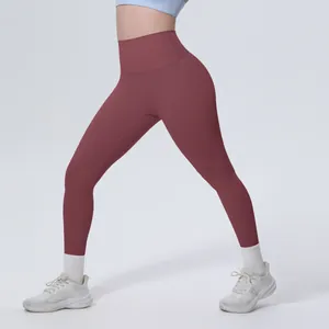 Dettaglio dei leggings da yoga a vita alta color rosso mattone con effetto push-up.
