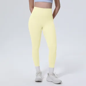 Dettaglio di leggings da yoga giallo pallido a vita alta con tessuto effetto nudo per fitness