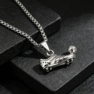 Close-up of stainless steel soccer shoe pendant with intricate metal texture and ball detail.