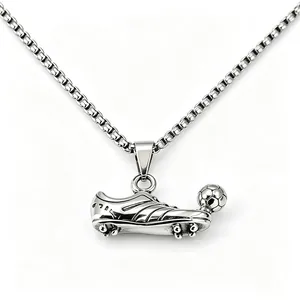 Detail view of a stainless steel soccer shoe and ball pendant on a box chain