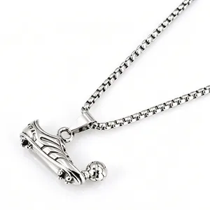 Close-up detail of stainless steel football shoe pendant and box chain for men