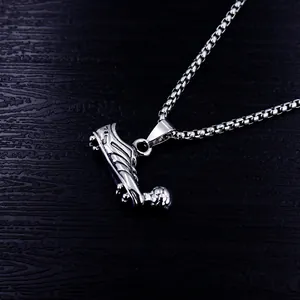 Detailed macro view of a stainless steel soccer cleat pendant necklace for men in hip-hop style.