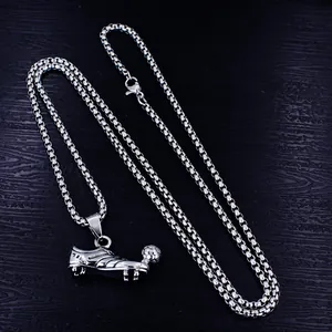 Detailed close-up showing the textures of a stainless steel soccer shoe and ball pendant
