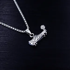 Detailed close-up of a silver-toned stainless steel football boot pendant on a box chain.