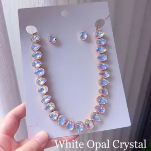 Primer plano detallado de un conjunto de collar y pendientes de cristal irisado en forma de gota