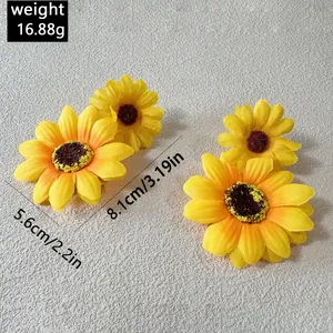 Vue détaillée de grandes boucles d'oreilles tournesol jaune avec poids et dimensions.